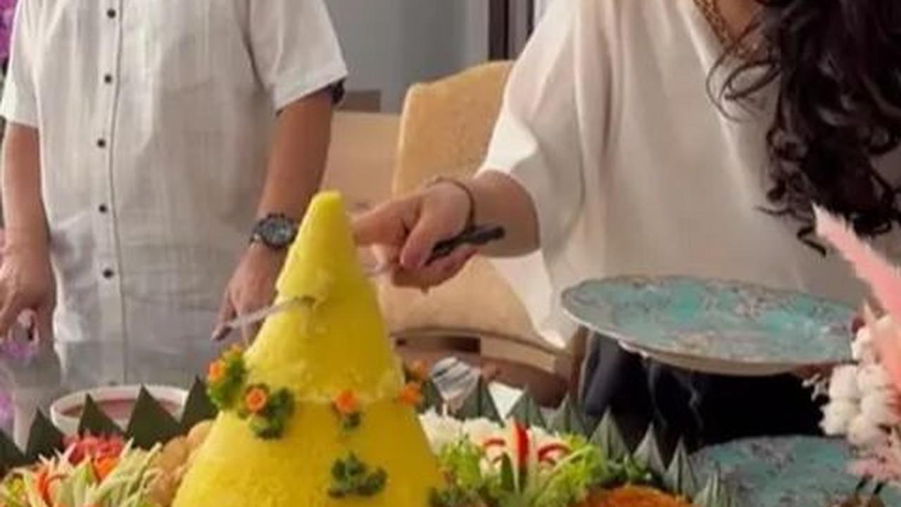 Setelah berdoa, Mayangsari memotong tumpeng dan memberikannya kepada suaminya yang tercinta.