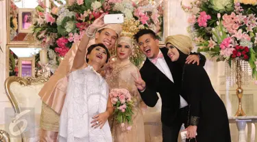 Presenter Indy Barends dan Indra Bekti serta istrinya, Aldila Jelita berwelfie bersama mempelai pengantin Ben Kasyafani - Nesyana Ayu Nabila pada resepsi pernikahan kedua Ben di kawasan Mega Kuningan, Jakarta, Sabtu (30/7). (Liputan6.com/Herman Zakharia)