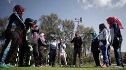 Wanita Palestina mendengarkan instruksi pelatih sebelum memulai sesi latihan bisbol di Khan Younis, Jalur Gaza, 19 Maret 2017. Sekelompok wanita muda muslim mencoba olahraga bisbol sebagai hiburan. (AP Photo/Khalil Hamra)