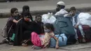 Sekelompok pelancong yang memakai masker menunggu di Lokmanya Tilak Terminus di Mumbai, Minggu (11/4/2021). Para ahli di India meyakini perilaku menganggap remeh aturan jarak sosial serta mengenakan masker di ruang publik menjadi pola yang meningkatkan kasus COVID-19. (AP/Rafiq Maqbool)