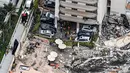 Pemandangan udara ini, menunjukkan tim penyelamat dan pencarian berada di lokasi runtuhnya sebagian menara apartemen tepi laut di Surfside, utara Miami, Kamis (24/6/2021). Penyebab keruntuhan yang mempengaruhi sekitar setengah dari 130 unit di kompleks, masih belum jelas. (CHANDAN KHANNA/AFP)