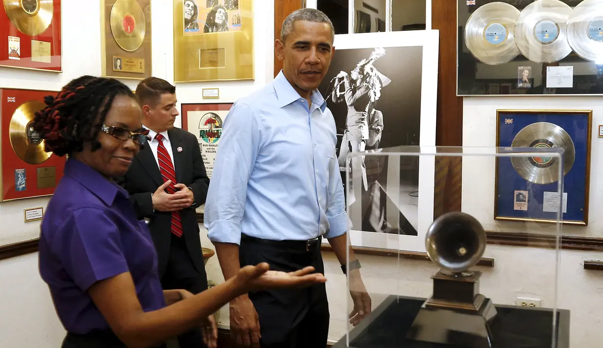 Presiden AS, Barcak Obama melihat piala Grammy Award yang didapat Bob Marley di Kingston, Jamaika (8/4). Presiden Obama datang ke museum sang legendaris musik Reggae sebelum melakukan pertemuan dengan para pemimpin dari CARICOM. (REUTERS/Jonathan Ernst)