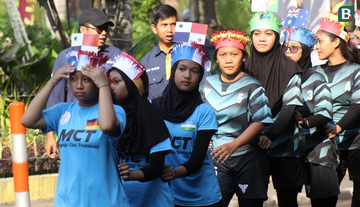 kelompok anak-anak kirab yang mengenakan jersey sepak bola ikut memeriahkan dalam kegiatan Trophy Experience Piala Dunia U-17 2023 di Surabaya, Minggu (29/10/2023). (Bola.com/Aditya Wany)