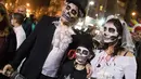 Sebuah keluarga yang mengenakan kostum serta mengecat wajahnya hingga mirip zombie mengikuti perayaan hari Purim di Tel Aviv (11/3). (AFP/Jack Guez)
