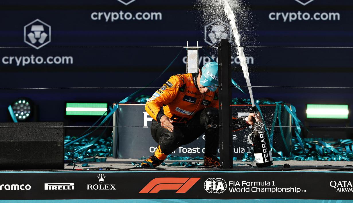 Pembalap Mc Laren, Lando Norris merayakan kemenangan dengan membuka sampanye saat Formula 1 GP Miami 2024 yang berlangsung di Miami International Autodrome, Miami, Florida, Minggu (05/05/2024). (AFP/Chris Graythen)