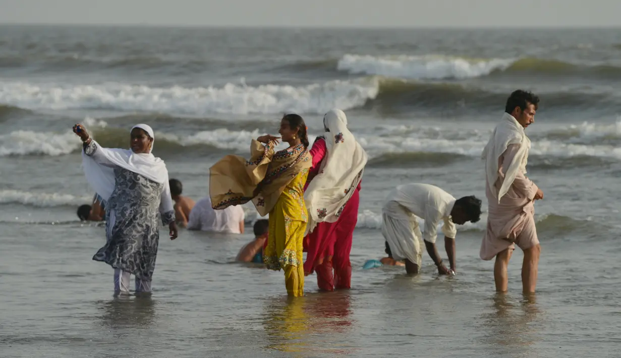 Warga Pakistan mendinginkan diri di pantai Clifton selama gelombang panas yang terjadi di Karachi, Senin (21/5). Suhu di Karachi, pada Senin (21/5), Gelombang panas terjadi saat warga Pakistan sedang menjalankan puasa bulan Ramadan. (AFP/RIZWAN TABASSUM)