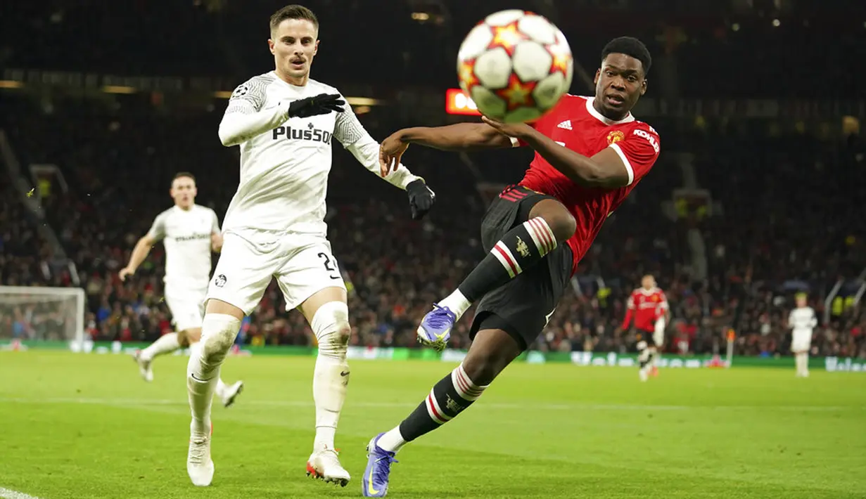 Pemain Manchester United Teden Mengi (kanan) berebut bola dengan pemain Young Boys Quentin Maceiras pada pertandingan sepak bola Grup F Liga Champions di Stadion Old Trafford, Manchester, Inggris, 8 Desember 2021. Pertandingan berakhir 1-1. (AP Photo/Dave Thompson)
