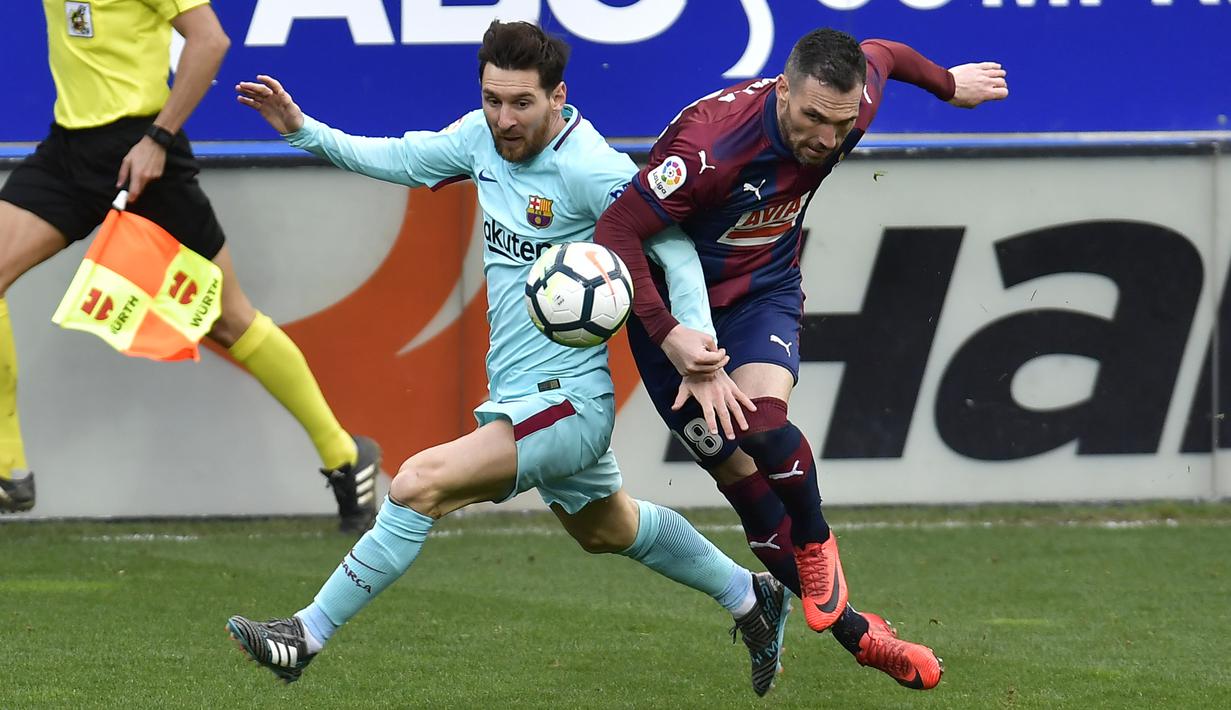 Duel Lionel Messi (kiri) dan pemain Eibar, Anaitz Arbilla pada lanjutan La Liga Santander di Ipurua stadium,  Eibar, (17/2/2018). Barcelona menang 2-0.(AP/Alvaro Barrientos)