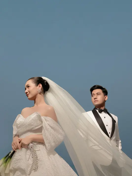 Gaun ini menampilkan desain ball gown dengan heartline yang romantis dan off shoulder yang elegan [@deaaannisa]