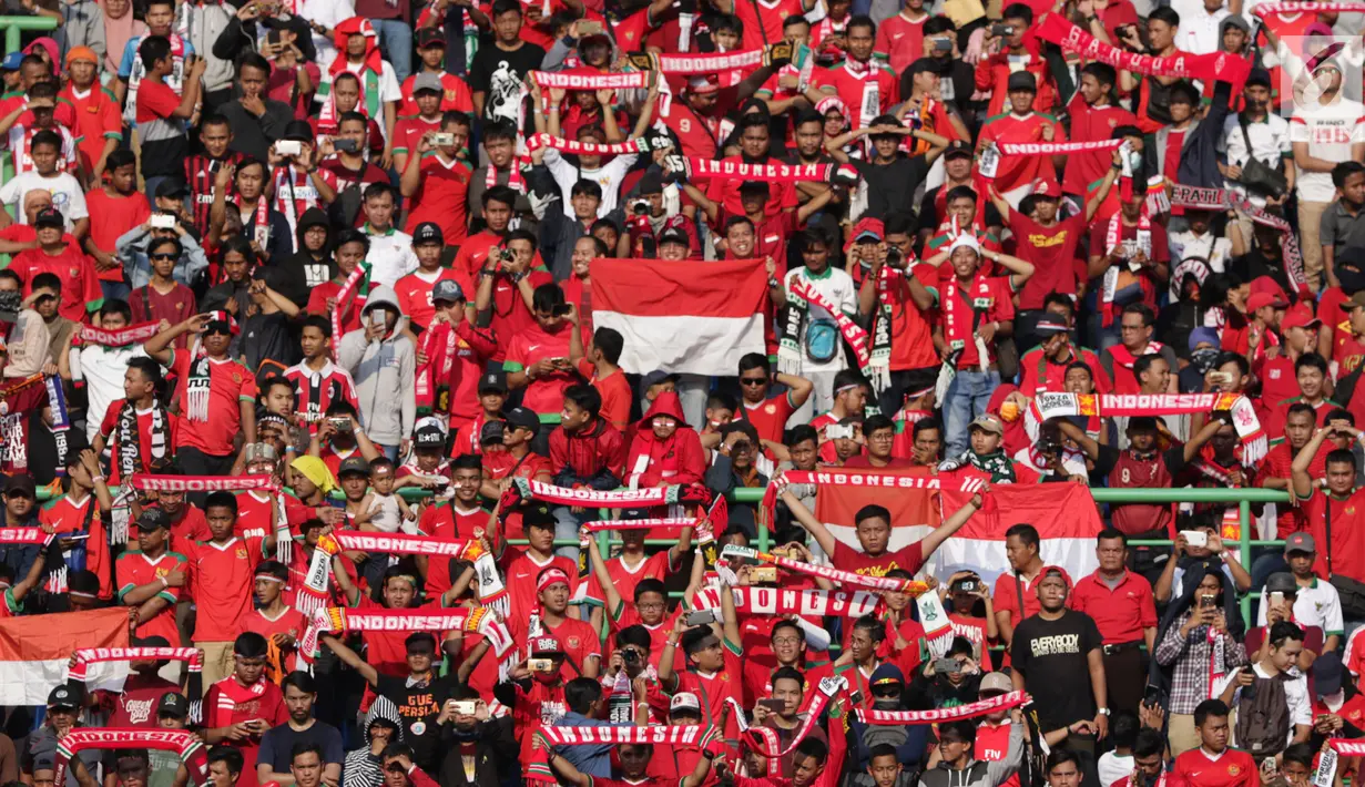Suporter Timnas Indonesia membentangkan syal saat menyaksikan laga persahabatan antara Indonesia melawan Fiji di Stadion Patriot Candrabhaga, Bekasi, Sabtu (9/2). Laga berakhir imbang 0-0. (Liputan6.com/Helmi Fithriansyah)