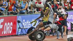 Usian Bolt terjatuh setelah ditabrak juru kamera yang menggunakan Segway saat merayakan kemenangan di nomor lari 200m Kejuaraan Dunia Atletik 2015 di Stadion Nasional, Beijing, Tiongkok. (27/8/2015). (Reuters)