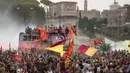 Suporter AS Roma bergembira saat bus membawa pemain AS Roma merayakan kemenangan juara Liga Konferensi Eropa UECL di depan Colosseum di Roma (26/5/2022). AS Roma menjuarai Konferensi Eropa UECL setelah mengalahkan Fayenoord dengan skor tipis 1-0. (AP Photo/Gregorio Borgia)