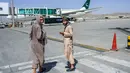 Anggota Taliban berpatroli di dekat pesawat Pakistan International Airlines (PIA) di bandara di Kabul, Senin (13/9/2021). Pesawat itu tercatat sebagai penerbangan komersial internasional pertama yang mendarat sejak Taliban merebut kembali kekuasaan di Afghanistan pada Agustus lalu (Bulent KILIC/AFP)