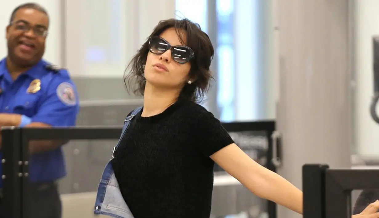 Camila Cabello melakukan keisengan di airport. Tahu dirinya dipotret paparazzi, Camila malah berpose kocak dan bikin ngakak. (Splash News/Cosmopolitan)