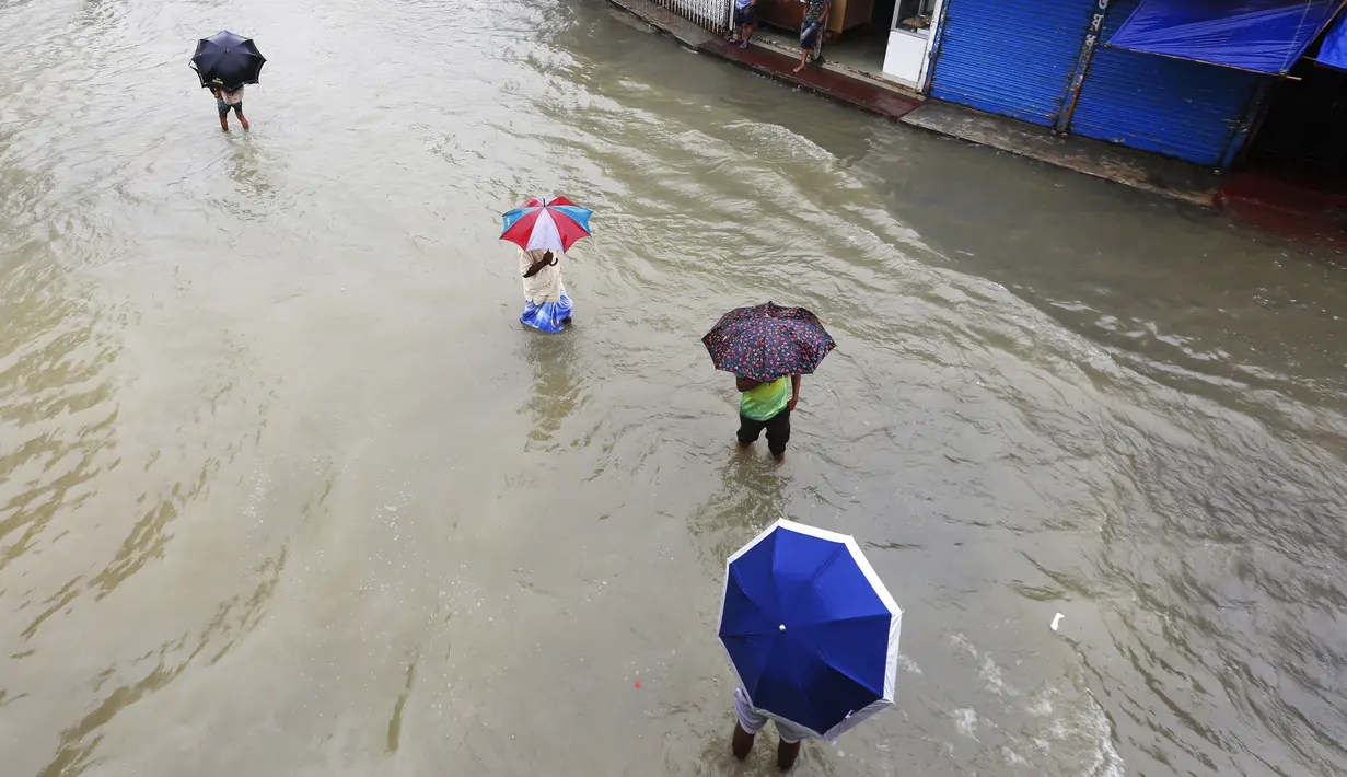 Sejumlah orang menerjang banjir yang merendam jalanan di Sunamganj, Bangladesh, Minggu (12/7/2020). Banjir di sejumlah wilayah Bangladesh telah memengaruhi kehidupan lebih dari 1,3 juta orang dan mengakibatkan puluhan ribu keluarga mengungsi. (Xinhua)