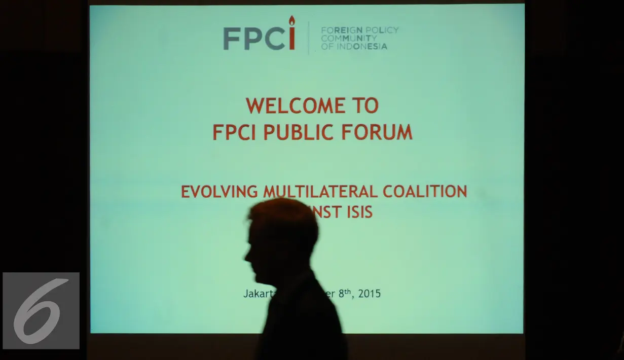 Peserta diskusi melintasi di depan proyektor diskusi FPCI Public Forum di Hotel Borobudur Jakarta, Selasa (8/12/2015). Diskusi membahas Pergeseran Koalisi Internasional Melawan ISIS dihadiri sejumlah duta besar. (Liputan6.com/Helmi Fithriansyah)