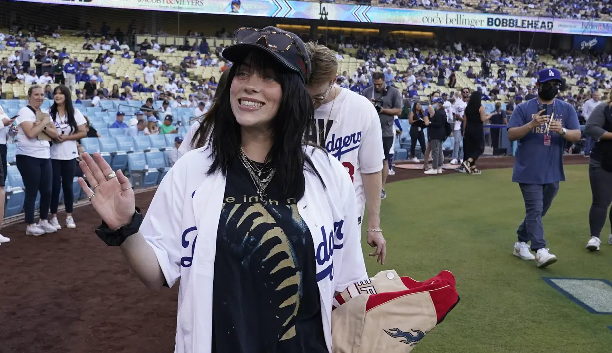 Penyanyi Billie Eilish melambaikan tangan kepada penggemar sebelum pertandingan bisbol antara Los Angeles Dodgers dan San Francisco Giants di Los Angeles, Amerika Serikat, 21 Juli 2022. Los Angeles Dodgers meraih kemenangan tipis menghadapi rival California, San Francisco Giants. (AP Photo/Marcio Jose Sanchez)