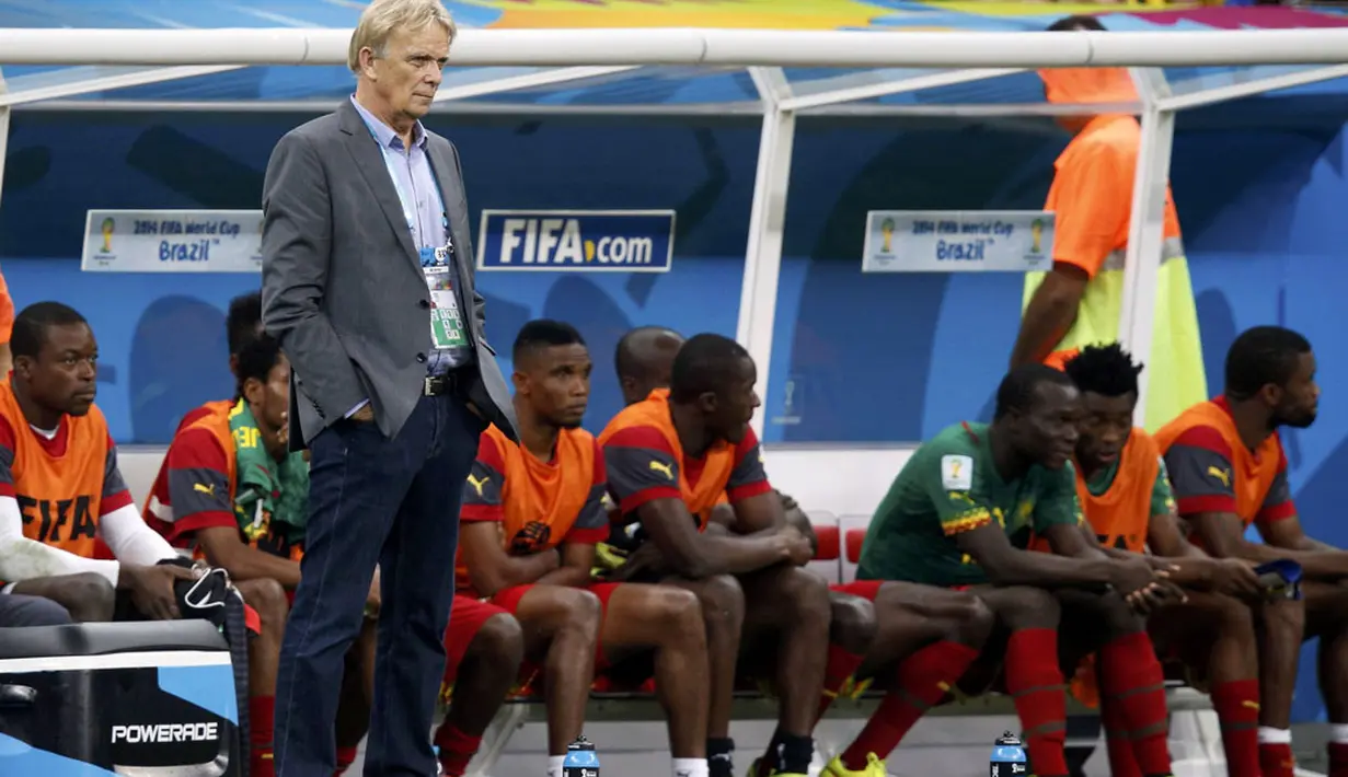 Pelatih Kamerun, Volker Finke (berdiri) menyaksikan anak asuhnya berlaga di penyisihan Piala Dunia 2014 Grup A melawan Tim Samba di Stadion Nasional Brasil, (24/6/2014). (REUTERS/Michael Dalder)