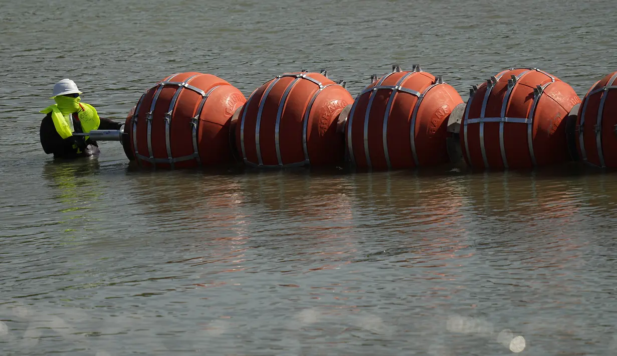 Penghalang baru ini muncul setelah serangkaian tenggelamnya migran di Sungai Rio Grande dalam beberapa hari terakhir yang menewaskan empat orang, termasuk seorang bayi, kata para pejabat. (AP Photo/Eric Gay)