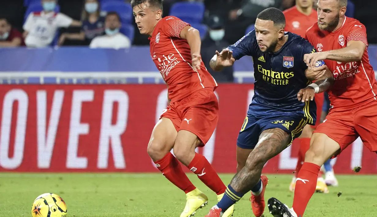 Penyerang Lyon, Memphis Depay, berebut bola dengan pemain Nimes pada laga lanjutan Liga Prancis di Stadion Groupama, Sabtu (19/9/2020) dini hari WIB. Lyon bermain imbang 0-0 atas Nimes. (AP Photo/Laurent Cipriani)