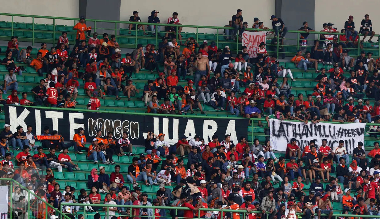Suporter membentangkan spanduk saat menyaksikan laga Persija melawan Mitra Kukar pada lanjutan Liga 1 Indonesia di Stadion Patriot Candrabhaga, Bekasi, Minggu (14/5). Laga kedua tim berakhir imbang 1-1. (Liputan6.com/Helmi Fithriansyah)