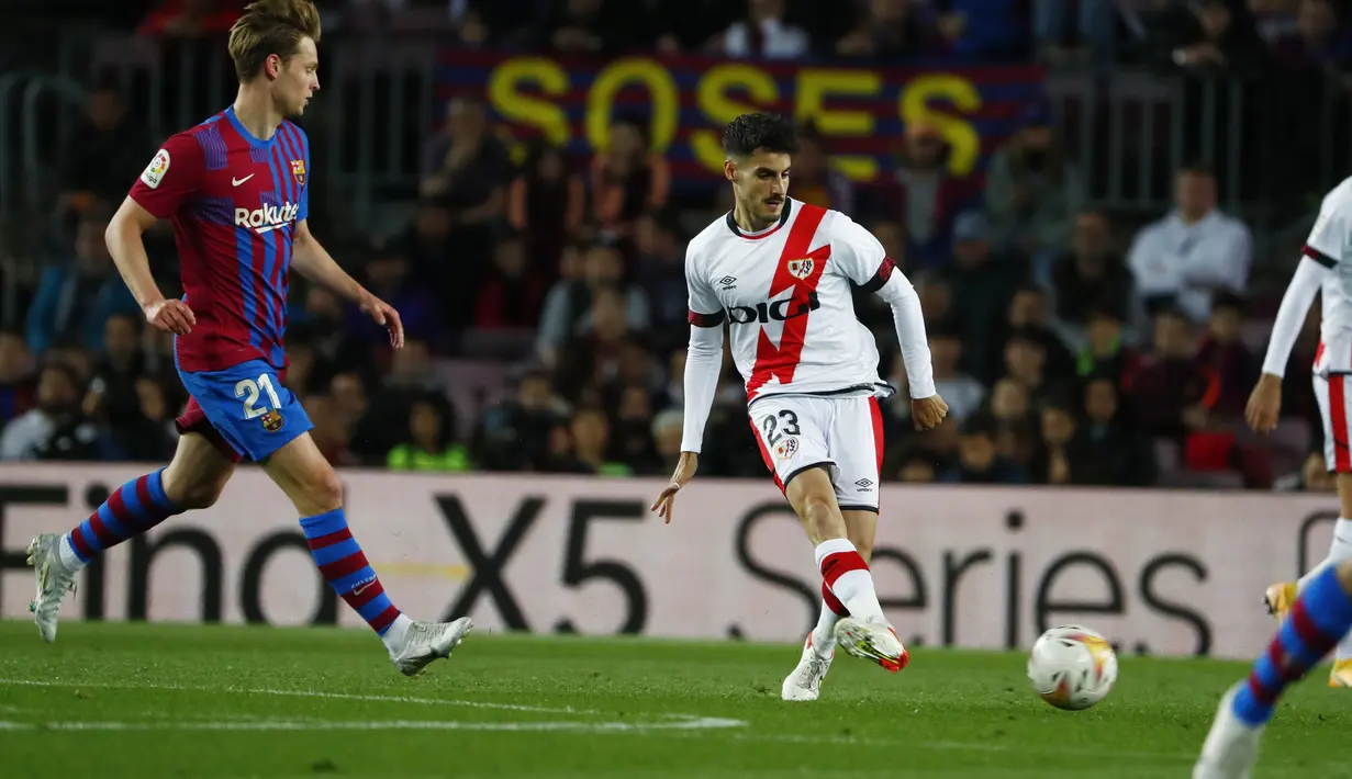 <p>Gelandang Rayo Vallecano, Oscar Valentin mengumpan bola dari kawalan gelandang Barcelona, Frenkie de Jong pada pertandingan lanjutan La Liga Spanyol di stadion Camp Nou di Barcelona, Spanyol, Senin (25/4/2022). Barcelona tumbang atas Rayo Vallecano 0-1. (AP Photo/Joan Monfort)</p>