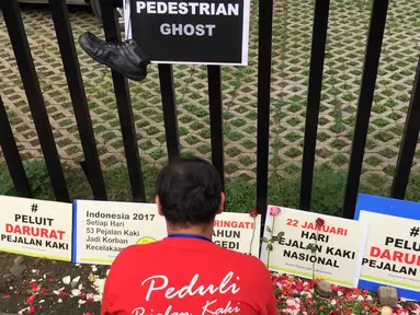 Aktivis Koalisi Pejalan Kaki menaburkan bunga di sekitar Halte Tugu Tani, Jakarta, Senin (22/1). Aksi ini diadakan untuk memperingati Hari Pedestrian sekaligus peringatan enam tahun tragedi Tugu Tani. (Liputan6.com/Immanuel Antonius)