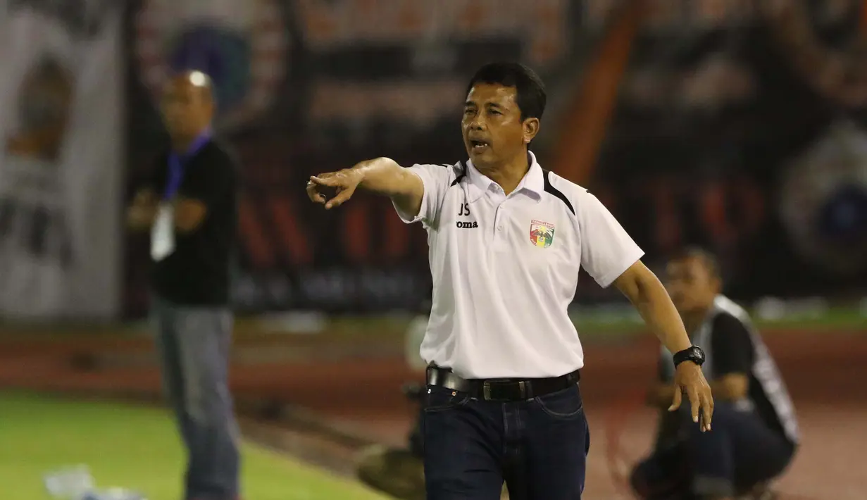 Pelatih Mitra Kukar, Jafri Sastra (2kanan) memberikan Instruksi kepada para pemainnya Pada laga Piala Jenderal Sudirman grup D di Stadion Manahan, Solo, Sabtu (12/12/2015). (Bola.com/Nicklas Hanoatubun)
