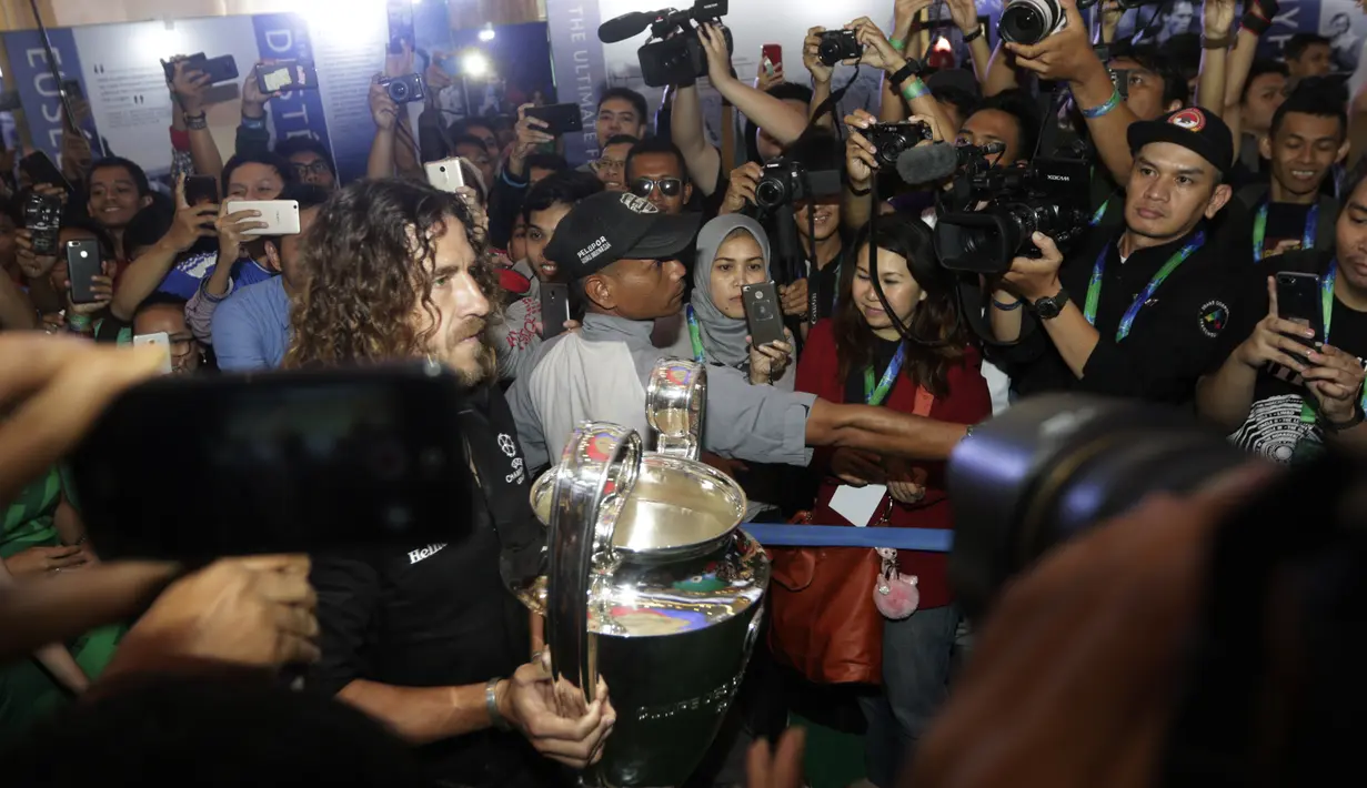 Legenda Barcelona, Carles Puyol, membawa trofi Liga Champions saat jumpa fans di Jakarta, Senin (11/3). Jumpa fans ini dalam rangka UEFA Champions League Trophy Tour di Indonesia. (Bola.com/Vitalis Yogi Trisna)