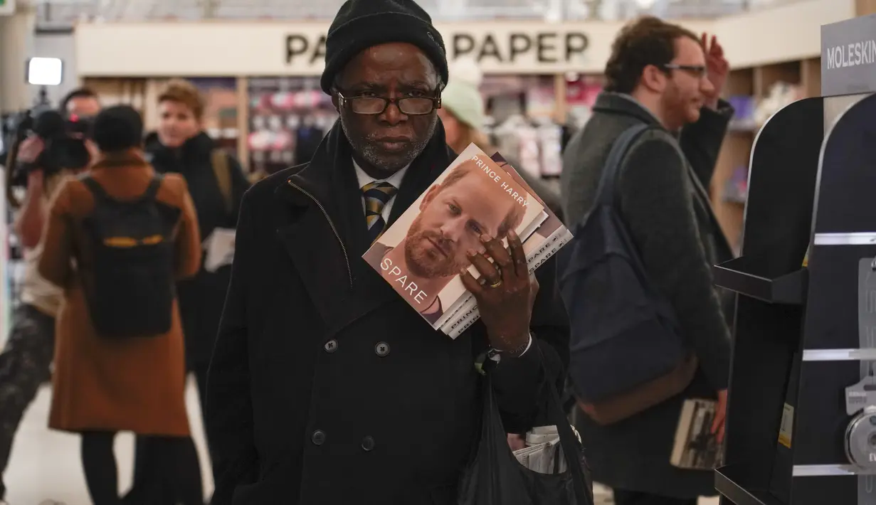 Seorang pelanggan memegang buku baru karya Pangeran Harry berjudul "Spare" di sebuah toko buku saat pembukaan tengah malam di London, Selasa (10/1/2023). Memoar Pangeran Harry "Spare" tiba di toko buku pada hari Selasa, menyediakan beragam potret Duke of Sussex dan keluarga kerajaan. (AP/Alberto Pezzali)