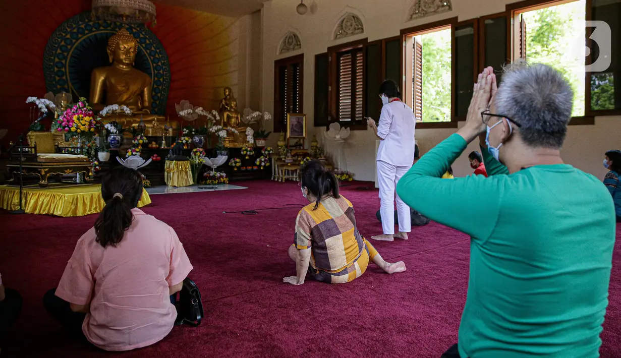 Umat Buddha mengikuti peringatan Hari Trisuci Waisak 2565 Tahun Buddhis di Vihara Jakarta Dhammacakka Jaya, Rabu (26/5/2021). Pelaksanaan upacara Trisuci Waisak 2565/2021 dirayakan oleh umat Buddha secara terbatas dengan menerapkan protokol kesehatan secara ketat. (Liputan6.com/Faizal Fanani)