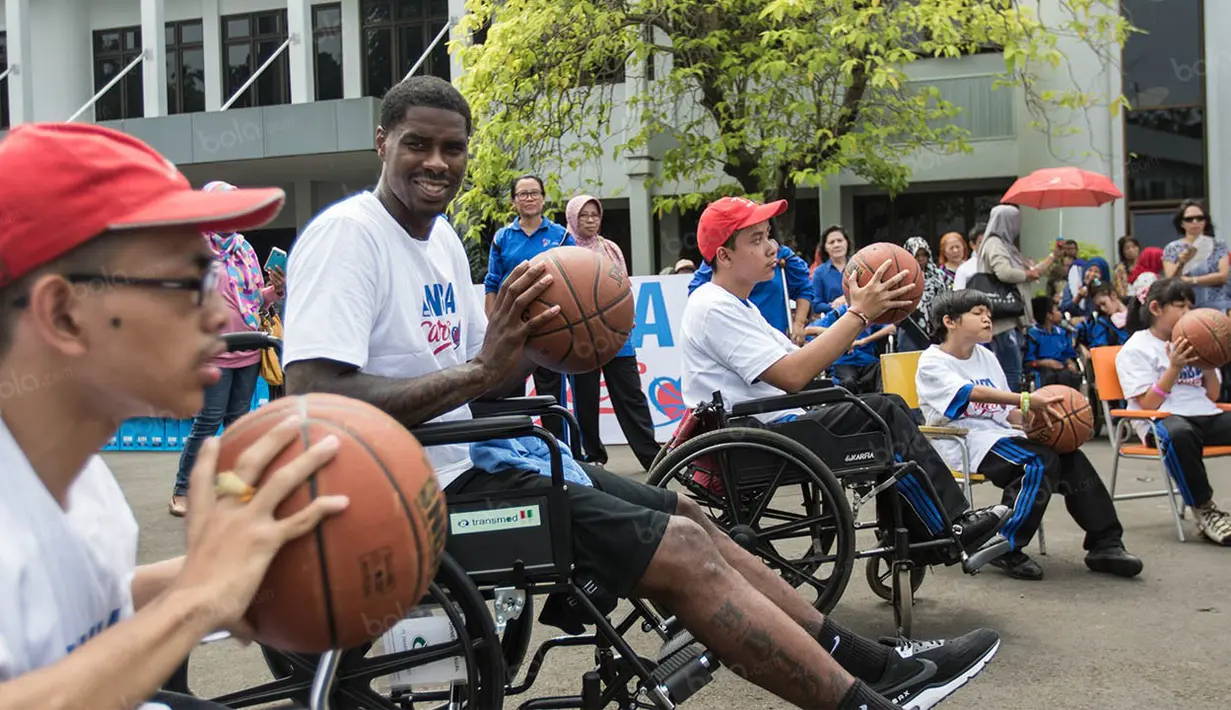 Pebasket NBA asal klub Charlotte Hornets, Marvin Williams, mengajarkan dribbling kepada para penyandang disabilitas. (Bola.com/Vitalis Yogi Trisna)