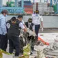 Petugas KNKT memeriksa bagian turbin pesawat Sriwijaya Air dihari kelima yang jatuh di perairan Pulau Seribu, di Dermaga JICT, Jakarta,  Rabu (13/1/2021). Potongan mesin jenis pesawat Boeing 737-500 yang ditemukan di perairan Kepulauan Seribu. (Liputan6.com/Faizal Fanani)