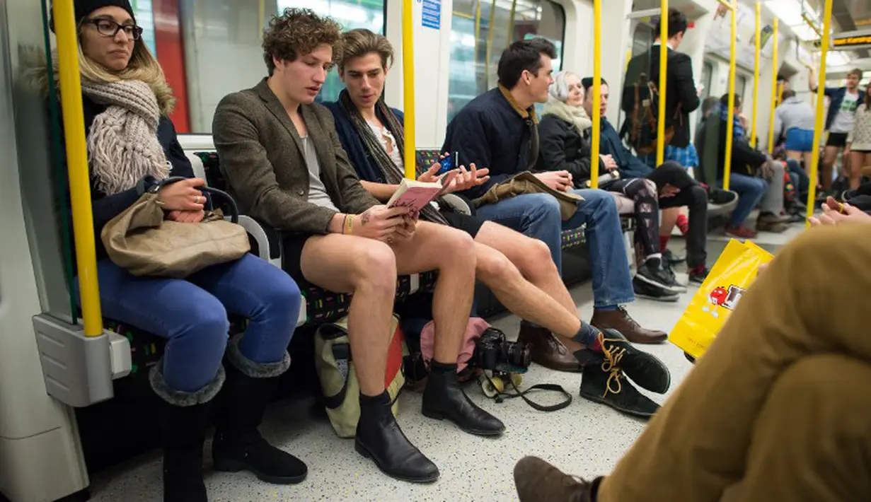 Dua penumpang pria tampak hanya mengenakan celana dalam saat menaiki kereta bawah tanah di London. Foto diambil Minggu (11/01/2015). (AFP PHOTO/LEON NEAL)