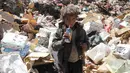 Seorang bocah laki-laki minum jus kadaluwarsa dari tumpukan sampah di sebuah tempat pembuangan akhir (TPA) di pinggiran Sanaa, Yaman, Rabu (16/11). Setiap hari para bocah di daerah itu mengumpulkan sampah untuk didaur ulang. (REUTERS/Mohamed al-Sayaghi)