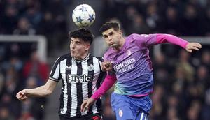 Pemain Newcastle United, Tino Livramento, duel udara degan pemain AC Milan, Christian Pulisic, dalam laga matchday 6 Liga Champions 2023/2024 di St. James' Park, Kamis (14/12/2023). (AP Photo/(Owen Humphreys)
