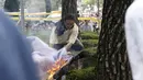 Seorang Warga ikut menyelamatkan pria yang membakar dirinya sendiri depan Kantor Kedubes Jepang, Seoul, Korea Selatan (12/8/2015). Ia menuntut permintaan maaf pemerintah Jepang yang memperkerjakan wanita korea pada Perang Dunia II. (REUTERS/Kim Hong-Ji)