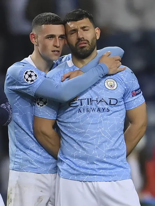 Pemain Manchester City, Phil Foden memeluk Sergio Aguero usai pertandingan melawan Chelsea pada babak final Liga Champions di Stadion Dragao di Porto, Portugal, Minggu (30/5/2021). Man City kalah atas Chelsea dengan skor 1-0. (David Ramos/Pool via AP)