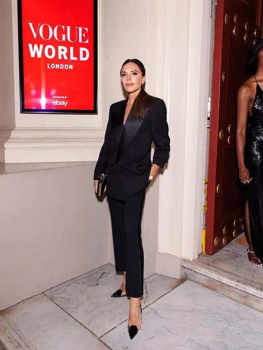 Lagi, potret Victoria Beckham dalam balutan busana serba hitam. Blazer dan celana panjang hitam, dipadu dengan pointed heels dan ia menenteng clutch yang menambah nuansa elegan dalam penampilannya secara keseluruhan. [Foto: Instagram/victoriabeckham]