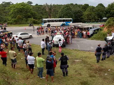 Kerabat dari para narapidana berkumpul di pos pemeriksaan menyusul kerusuhan yang terjadi di dalam penjara kota Amazon, Brasil, Senin (2/1). Setidaknya 60 orang tewas akibat kerusuhan yang dipicu persaingan antargeng narkoba. (REUTERS/Michael Dantas)