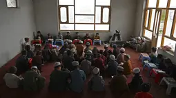 Anak-anak membaca Alquran selama bulan suci Ramadhan di sebuah masjid di pinggiran Kabul, Afghanistan, Selasa (27/4/2021).  Bulan Ramadhan menjadi momen untuk memperbanyak amalan, termasuk ketekunan menjalani tadarus Alquran. (WAKIL KOHSAR / AFP)