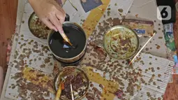 Perajin menyelesaikan salah satu tahapan produksi batik Marunda di Rusunawa Marunda, Jakarta, Selasa (14/7/2020). Kreasi para ibu tersebut dilakukan mulai dari Senin hingga Kamis. (Liputan6.com/Herman Zakharia)
