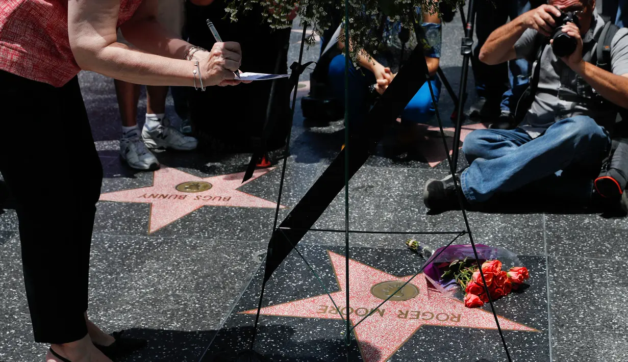 Produser Walk of Fame Ana Martinez menulis sebuah catatan untuk mengenang aktor Inggris, Roger Moore, di Hollywood, Los Angeles, Selasa (23/5). Aktor dikenal karena memerankan James Bond itu meninggal dunia pada usia 89 tahun. (AP Photo/Jae C. Hong)