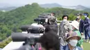 Pengunjung menggunakan teropong untuk melihat sisi Korea Utara dari observatorium unifikasi di Paju, Korea Selatan, Kamis (12/5/2022). Korea Utara memberlakukan lockdown nasional usai mengkonfirmasi kasus COVID-19 untuk pertama kalinya. Kasus subvarian Omicron BA.2 itu terdeteksi di Pyongyang. (AP Photo/Lee Jin-man)