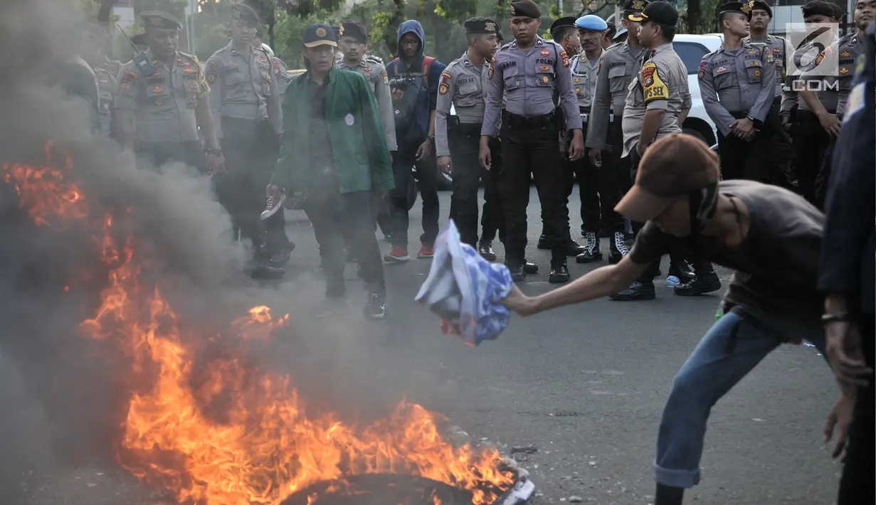 Mahasiswa gabungan se-Jabodetabek membakar ban bekas saat menggelar aksi unjuk rasa di depan Istana Merdeka, Jakarta, Selasa (16/7/2019). Dalam aksi ini sempat terjadi aksi saling dorong dengan pihak kepolisian. (merdeka.com/Iqbal S. Nugroho)