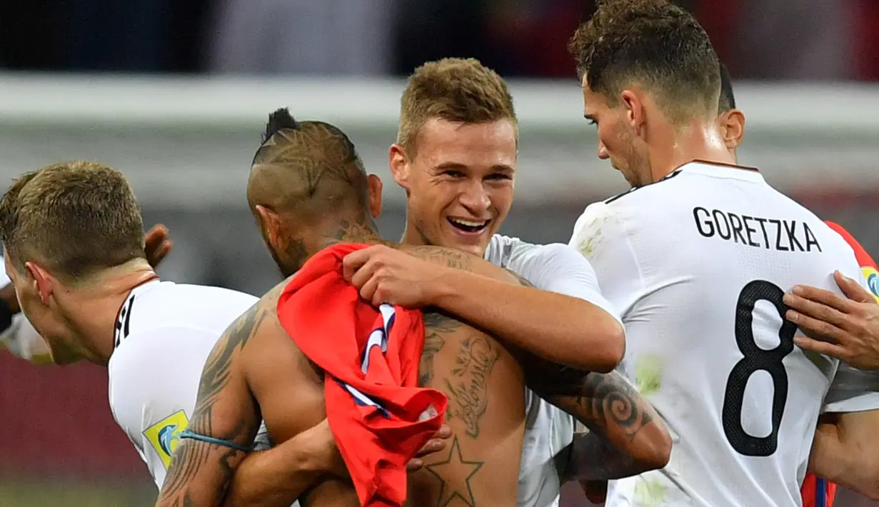 Pemain Chili, Arturo Vidal berpelukan dengan pemain Jerman, Joshua Kimmich usai laga pada grup B Piala Konfederasi 2017 di Kazan Arena Stadium, Kazan (22/6/2017). (AFP/Yuri Cortez)