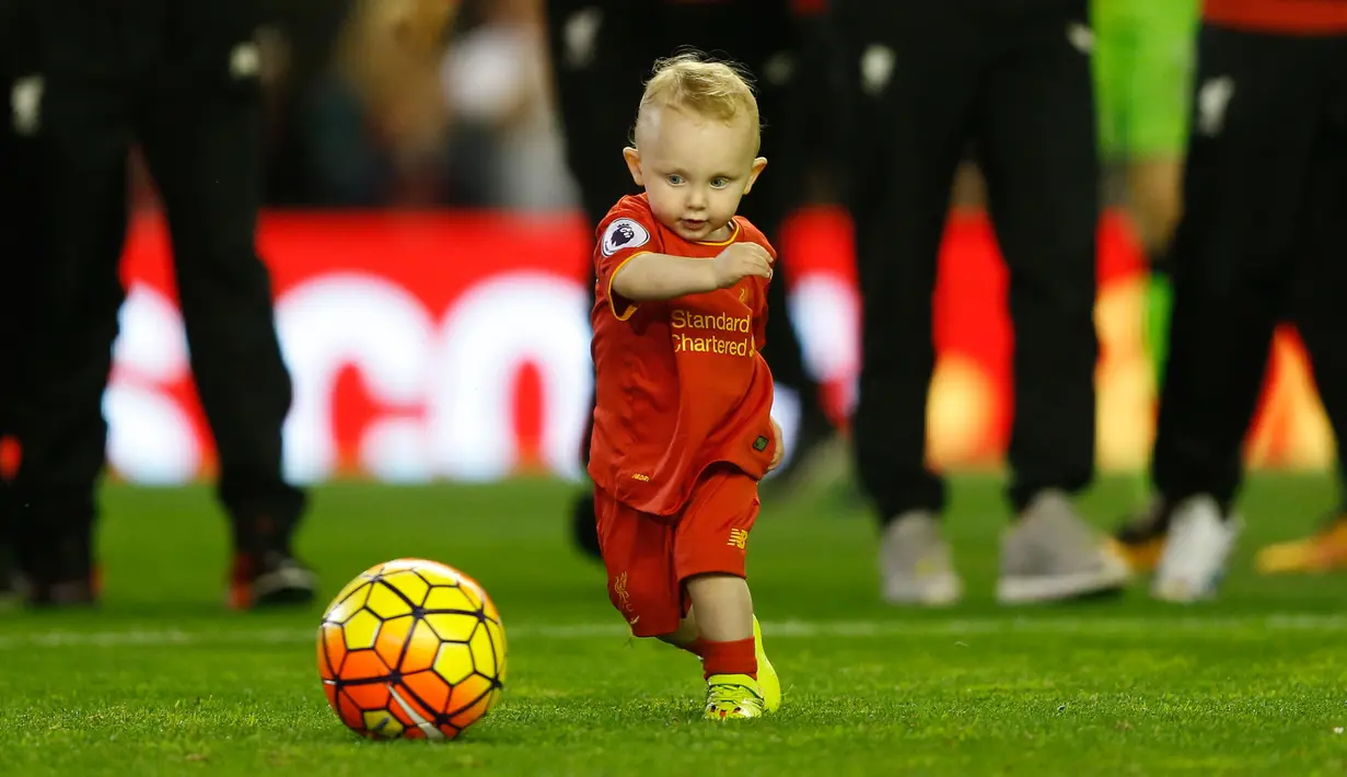 Seorang anak bermain bola di dalam lapangan saat salam penghormatan setelah berakhirnya pertandingan melawan Chelsea pada pertandingan Liga Inggris di Anfield, Liverpool, 12 Mei 2016. (Reuters / Carl Recine)