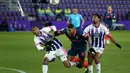 Gelandang Sevilla, Diego Carlos (tengah) dihadang dua pemain Real Valladolid, Joaquin Fernandez (kiri) dan Saidy Jano dalam laga lanjutan Liga Spanyol 2020/2021 pekan ke-28 di Jose Zorrilla Stadium, Valladolid, Sabtu (20/3/2021). Sevilla bermain imbang 1-1 dengan Valladolid. (AFP/Cesar Manso)