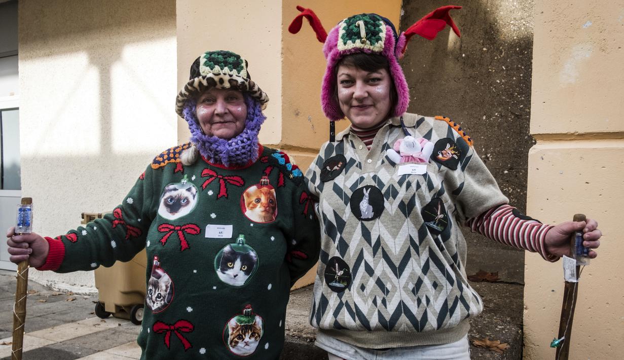 Anne dan putrinya Charline saat berlangsungnya Kejuaraan Dunia Sweater Terjelek di kota Albi, Prancis pada 1 Desember 2018. Peserta yang mengikuti kompetisi, terbagi dalam kategori anak-anak, perorangan, dan keluarga. (ERIC CABANIS / AFP)