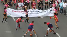 Para atlet yang mendukung penyelenggaraan Asian Games memeriahkan parade di Jalan MH Thamrin, Jakarta, Minggu (15/5). Total ada 42 rombongan dari berbagai komunitas, serta BUMN dan BUMS. (Liputan6.com/Arya Manggala)